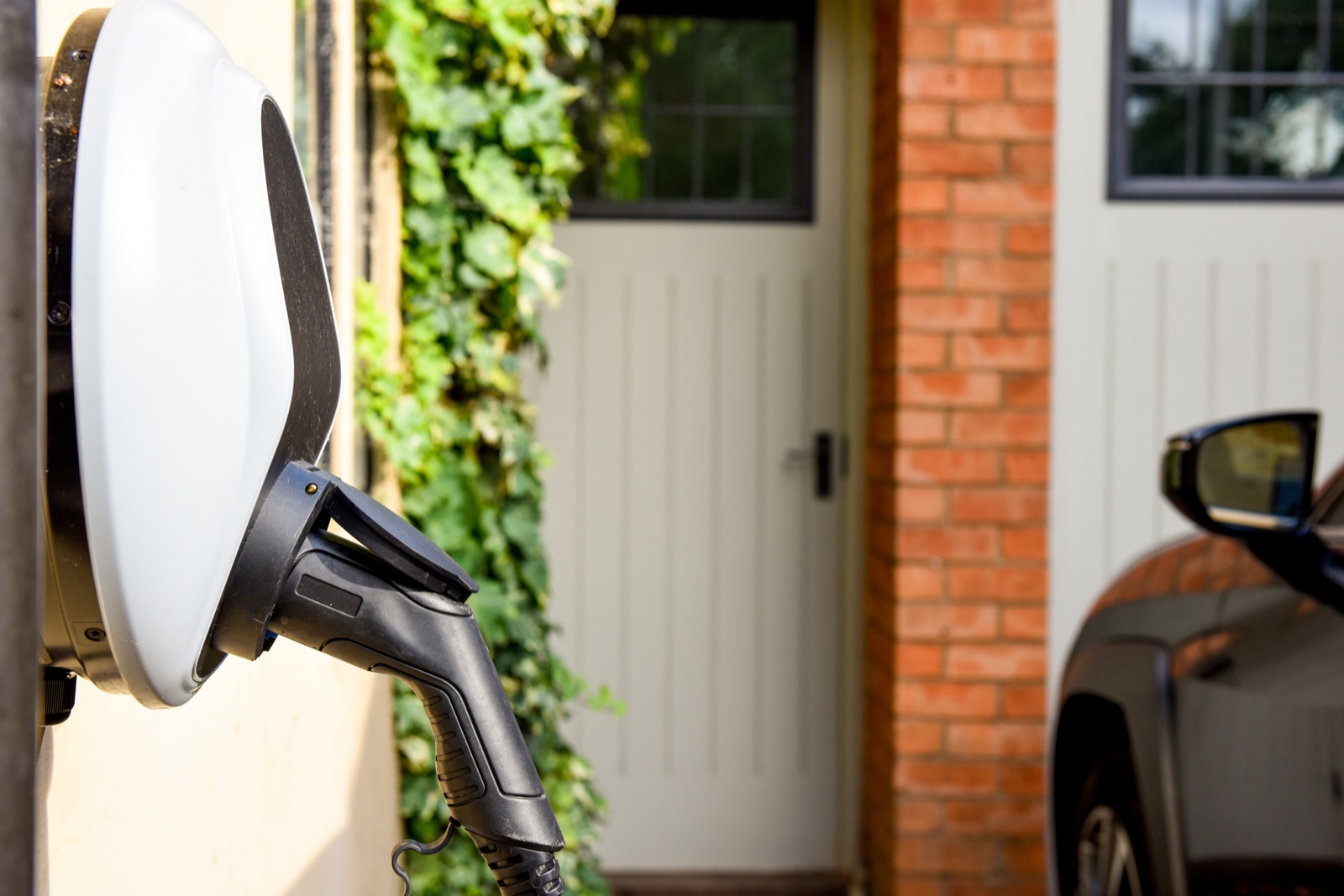 Wall-mounted Level 2 home EV charging station installed beside a garage in the Baltimore area